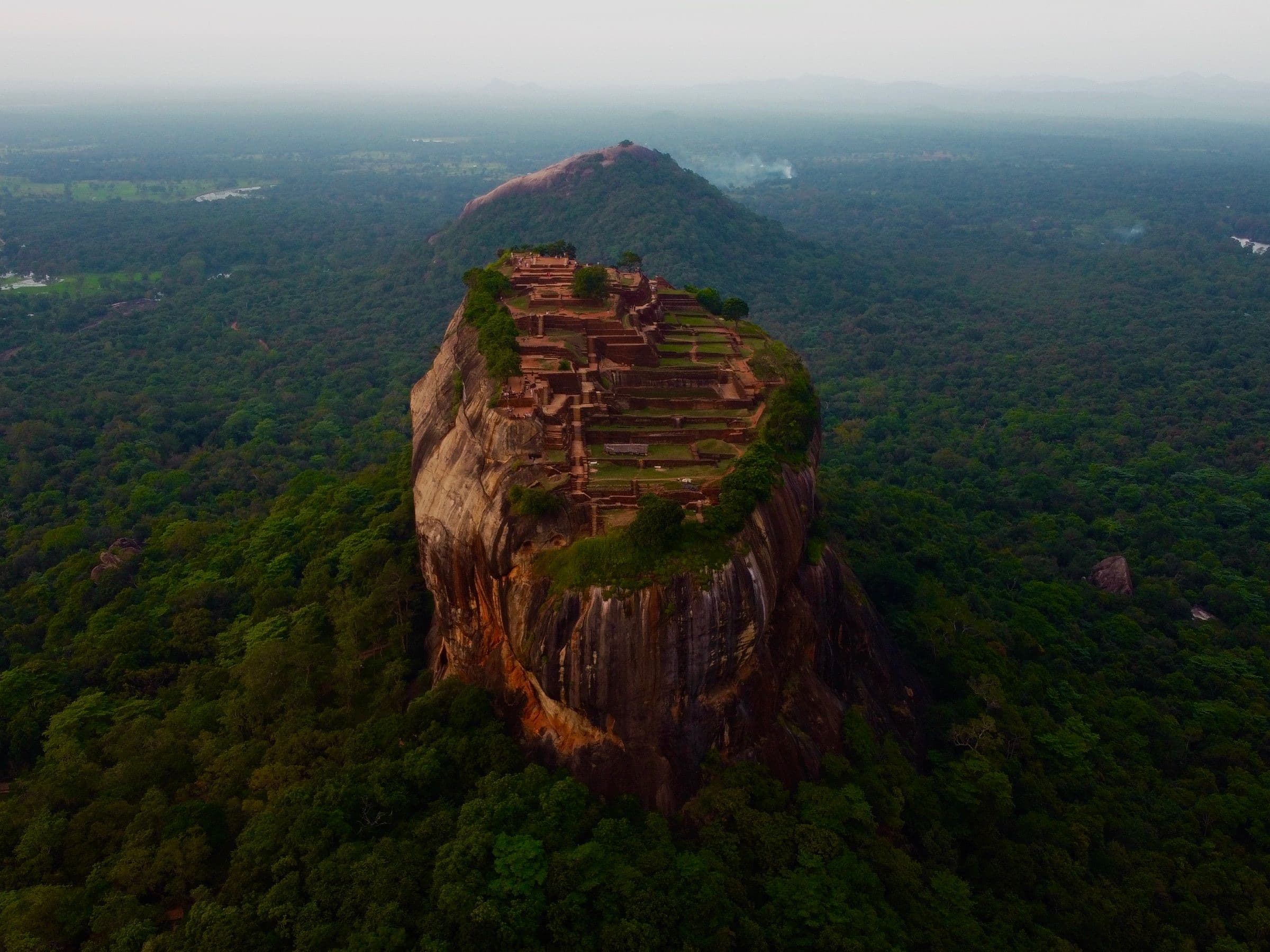 Aerial view of Sigiriya Rock Fortress rising above the forest