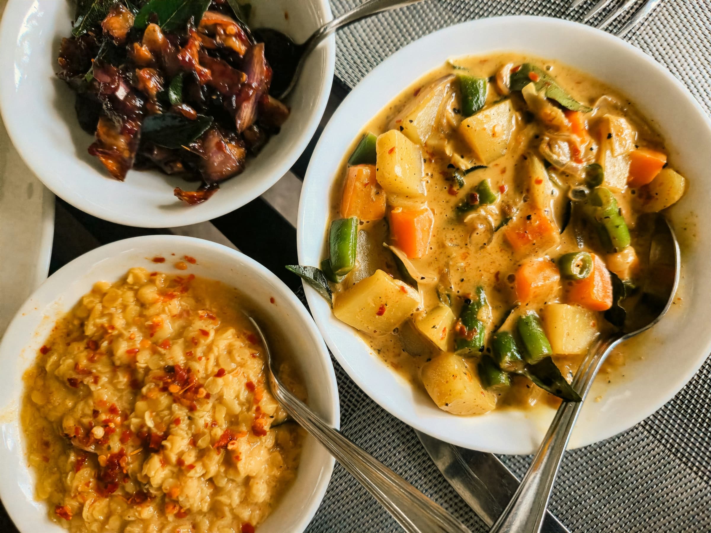 Sri Lankan vegetable curries and dhal served in white bowls