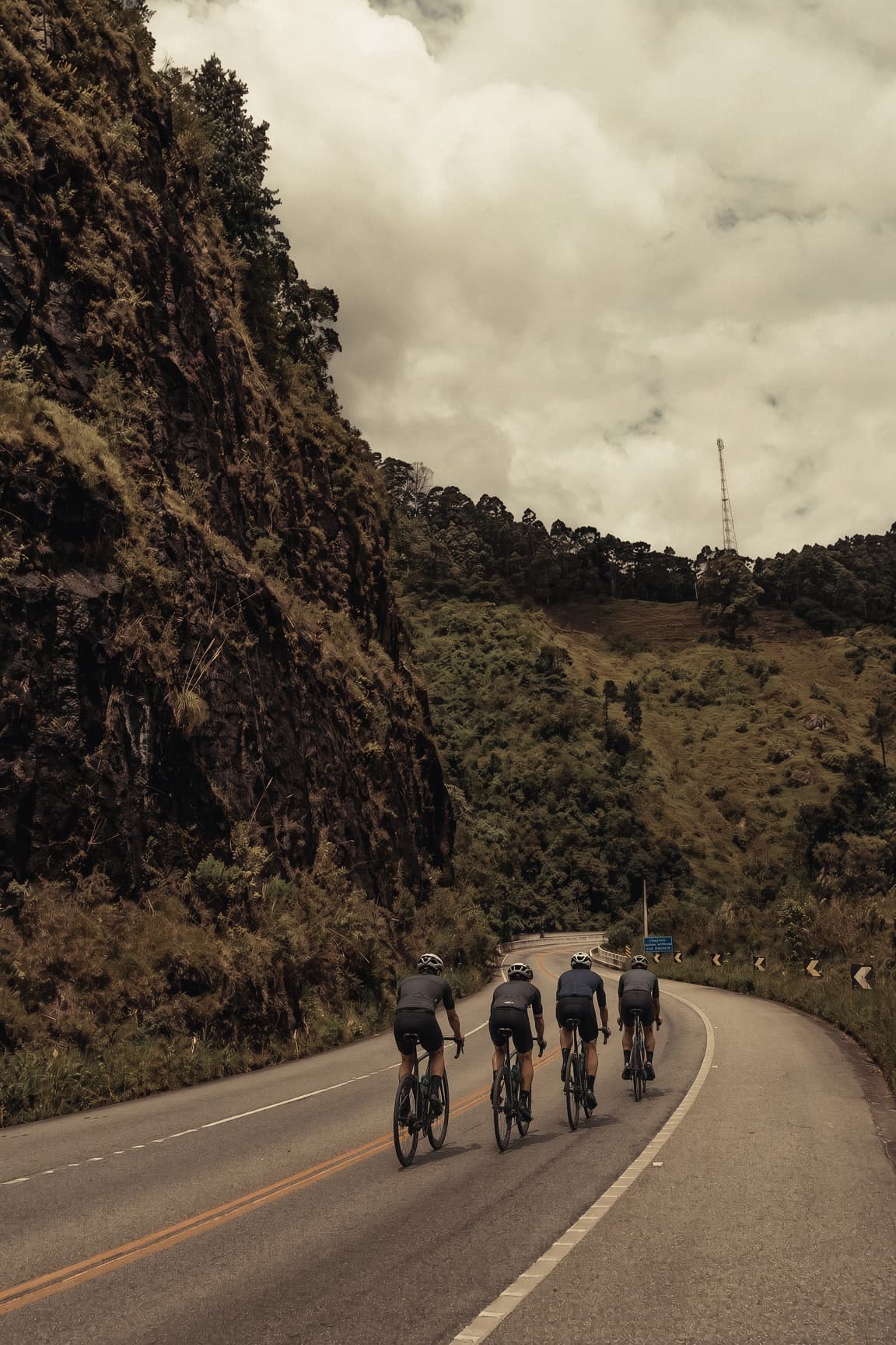Group of cyclists descending a winding mountain road in Sri Lanka