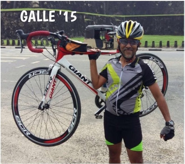 Damshike’s dad in cycling kit, holding his road bike in Galle